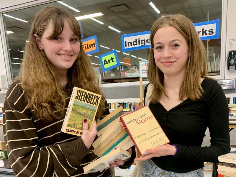 Two girls pose holding books