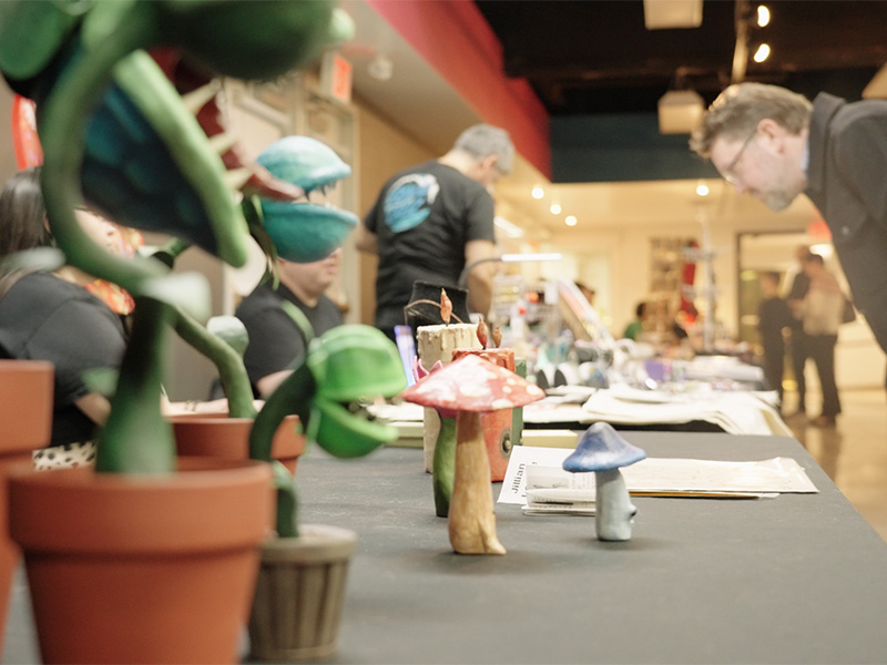 Hand-made crafts of plants and mushrooms on a table at a craft fair